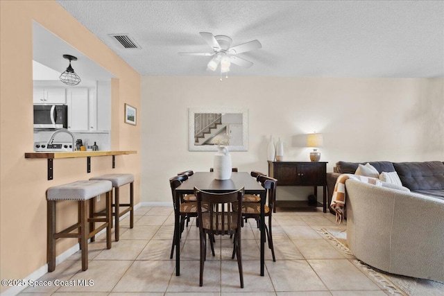 149 Kristi Dr, Indian Harbour Beach, FL 32937 - dining space with ceiling fan, light tile patterned floors, a textured ceiling, baseboards, and stairs