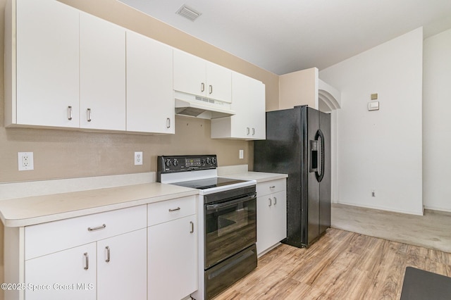 3220 Lowry Blvd SE, Palm Bay, FL 32909 - kitchen with under cabinet range hood, black appliances, light wood-type flooring, white cabinetry, and light countertops