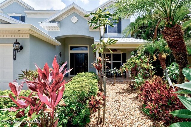 121 Amherst Ln, Sebastian, FL 32958 - view of exterior entry with stucco siding and an attached garage