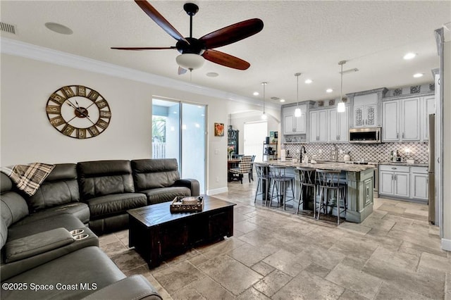 121 Amherst Ln, Sebastian, FL 32958 - living room with ceiling fan, ornamental molding, stone tile flooring, recessed lighting, and baseboards