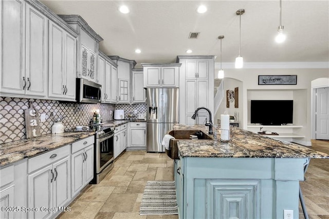 121 Amherst Ln, Sebastian, FL 32958 - kitchen with stainless steel appliances, arched walkways, crown molding, stone tile flooring, and backsplash