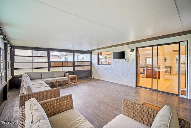 7020 Kaylor Ave, Cocoa, FL 32927 - sunroom with outdoor lounge area, wood finished floors, and a textured wall