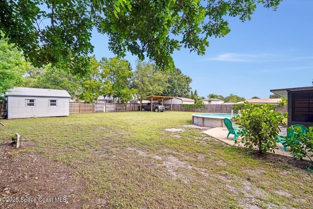 7020 Kaylor Ave, Cocoa, FL 32927 - fenced backyard featuring an outdoor structure, a detached carport, and a patio