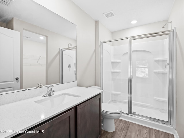999 Zambrana St SE, Palm Bay, FL 32909 - bathroom with a stall shower, toilet, vanity, wood finished floors, and a walk in closet