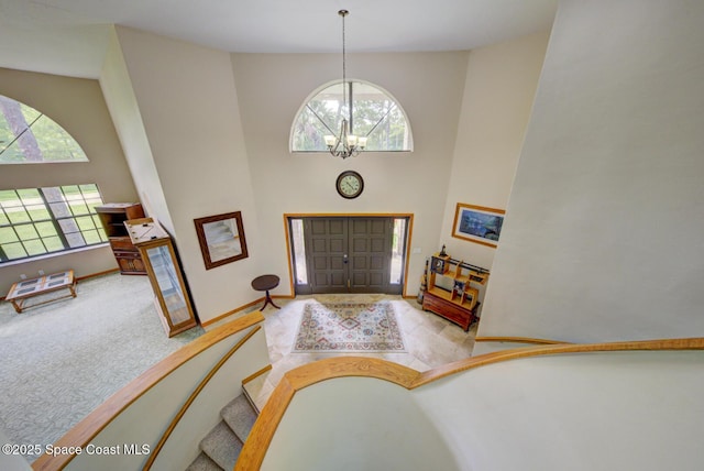 4956 Corfu Dr, Cocoa, FL 32926 - carpeted foyer entrance featuring a high ceiling, a chandelier, and baseboards
