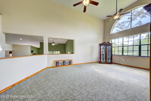 4956 Corfu Dr, Cocoa, FL 32926 - unfurnished living room with carpet flooring, a ceiling fan, a towering ceiling, and baseboards
