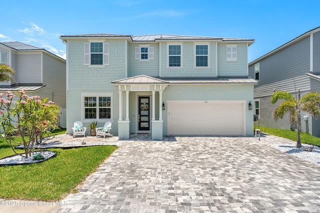 786 Clearwater Ave, Satellite Beach, FL 32937 - view of front facade featuring a standing seam roof, a metal roof, decorative driveway, and a garage