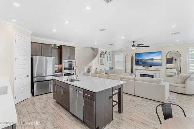 786 Clearwater Ave, Satellite Beach, FL 32937 - kitchen featuring stainless steel appliances, a kitchen bar, ornamental molding, dark brown cabinets, and ceiling fan