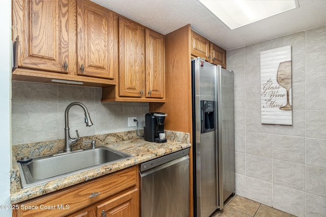 403 Seaport Blvd Unit T145, Cape Canaveral, FL 32920 - kitchen featuring appliances with stainless steel finishes, a sink, brown cabinetry, and light stone counters