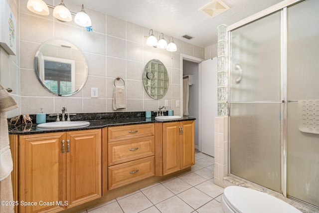 403 Seaport Blvd Unit T145, Cape Canaveral, FL 32920 - full bathroom featuring a shower stall, double vanity, tile patterned floors, tile walls, and toilet