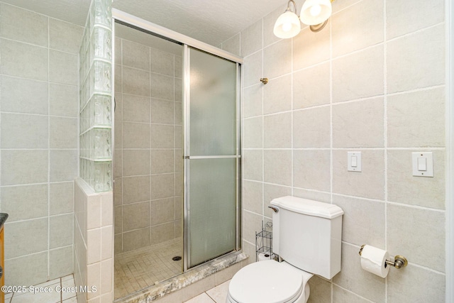 403 Seaport Blvd Unit T145, Cape Canaveral, FL 32920 - bathroom featuring tile walls, a shower stall, toilet, and tile patterned flooring