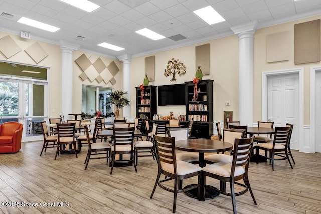 5209 Eleuthra Cir, Vero Beach, FL 32967 - dining area with ornate columns, a towering ceiling, ornamental molding, and light wood-style flooring