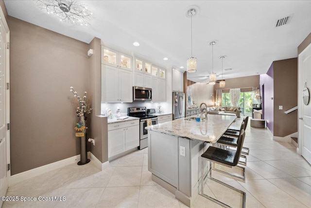 1039 Steven Patrick Ave, Indian Harbour Beach, FL 32937 - kitchen featuring stainless steel appliances, open floor plan, a sink, an island with sink, and glass insert cabinets