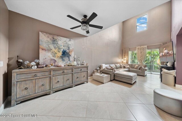 1039 Steven Patrick Ave, Indian Harbour Beach, FL 32937 - living area with ceiling fan, healthy amount of natural light, a towering ceiling, light tile patterned floors, and baseboards
