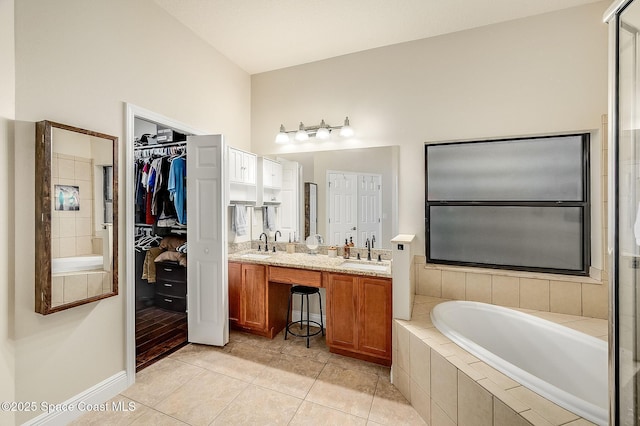 4725 Papaya St, Cocoa, FL 32926 - bathroom with a garden tub, tile patterned flooring, double vanity, and a walk in closet