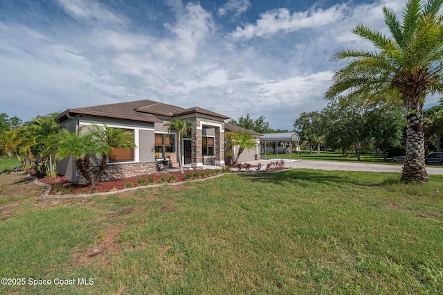 4725 Papaya St, Cocoa, FL 32926 - view of front of house featuring driveway, stucco siding, stone siding, a front yard, and a carport