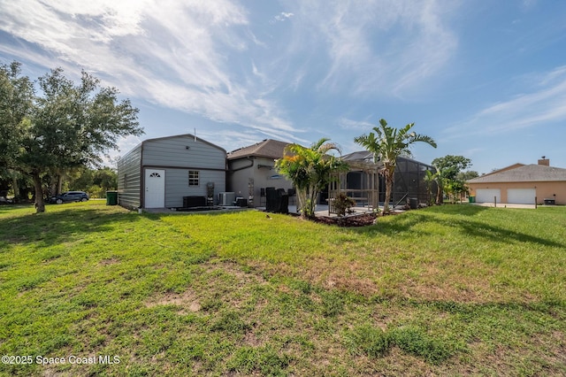4725 Papaya St, Cocoa, FL 32926 - back of house with a yard, glass enclosure, cooling unit, and a garage