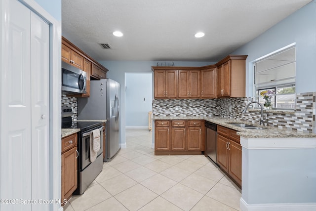 822 Lamplighter Dr NW, Palm Bay, FL 32907 - kitchen with stainless steel appliances, a sink, decorative backsplash, brown cabinets, and recessed lighting