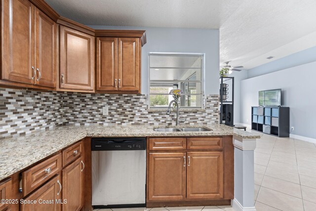 822 Lamplighter Dr NW, Palm Bay, FL 32907 - kitchen with stainless steel dishwasher, a sink, brown cabinets, decorative backsplash, and a textured ceiling
