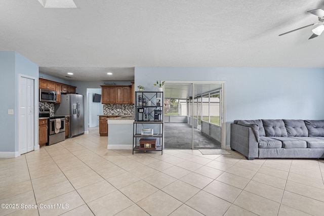 822 Lamplighter Dr NW, Palm Bay, FL 32907 - kitchen with appliances with stainless steel finishes, open floor plan, tasteful backsplash, ceiling fan, and brown cabinets