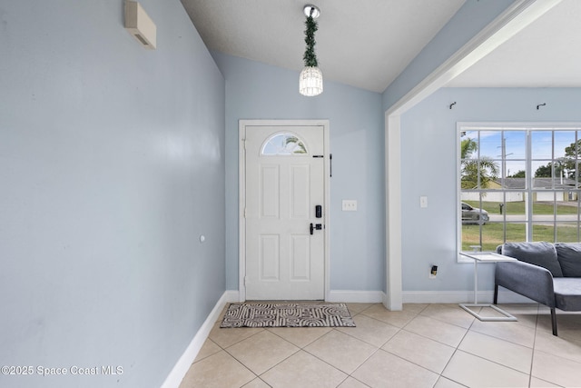 822 Lamplighter Dr NW, Palm Bay, FL 32907 - foyer with baseboards, light tile patterned flooring, and lofted ceiling