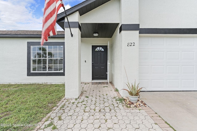 822 Lamplighter Dr NW, Palm Bay, FL 32907 - view of exterior entry with stucco siding and a garage
