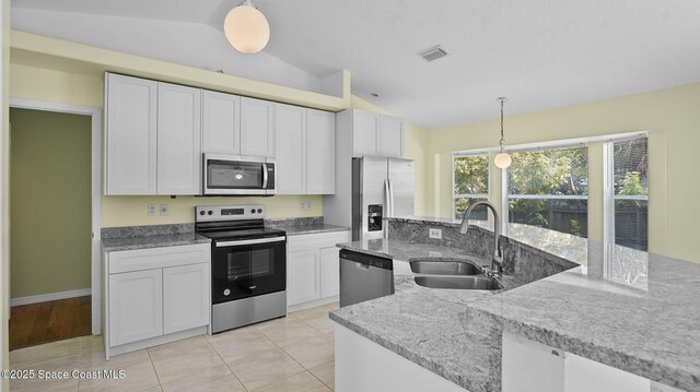 525 Banana Blvd, Merritt Island, FL 32952 - kitchen featuring stainless steel appliances, vaulted ceiling, a sink, hanging light fixtures, and white cabinets