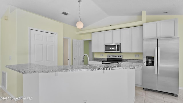 525 Banana Blvd, Merritt Island, FL 32952 - kitchen with appliances with stainless steel finishes, vaulted ceiling, white cabinets, light tile patterned floors, and decorative light fixtures