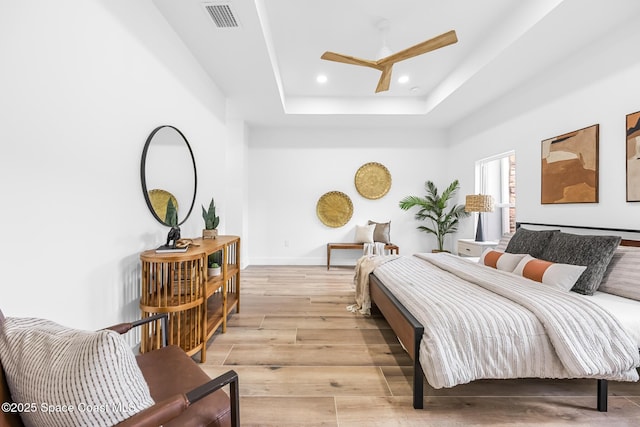 1313 Worth Ct NE, Palm Bay, FL 32905 - bedroom featuring light wood finished floors, a tray ceiling, recessed lighting, baseboards, and a ceiling fan