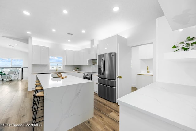 1313 Worth Ct NE, Palm Bay, FL 32905 - kitchen featuring modern cabinets, stainless steel appliances, white cabinets, a breakfast bar area, and recessed lighting