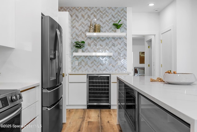 1313 Worth Ct NE, Palm Bay, FL 32905 - kitchen with stainless steel appliances, wine cooler, white cabinetry, light countertops, and recessed lighting