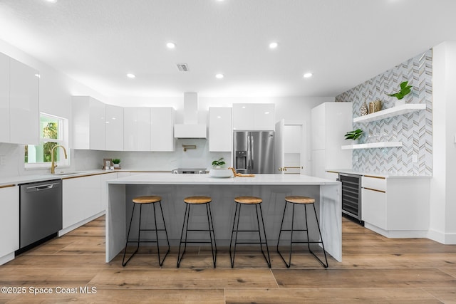 1313 Worth Ct NE, Palm Bay, FL 32905 - kitchen with stainless steel appliances, modern cabinets, wine cooler, open shelves, and white cabinets