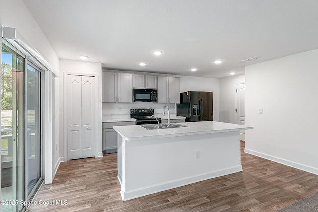 2205 Sapelo Ave SE, Palm Bay, FL 32909 - kitchen with black appliances, gray cabinets, a sink, light countertops, and wood finished floors