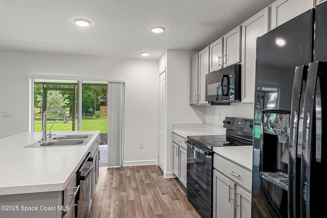2205 Sapelo Ave SE, Palm Bay, FL 32909 - kitchen featuring black appliances, a sink, light countertops, wood finished floors, and recessed lighting