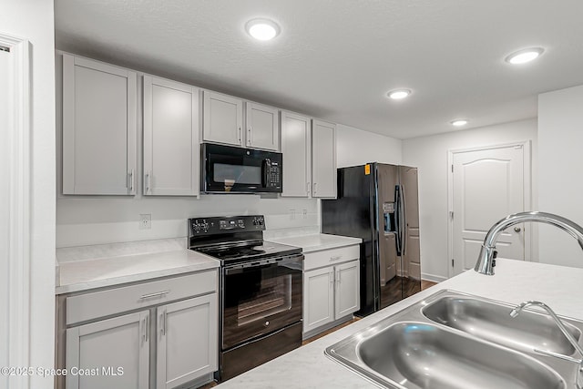 2205 Sapelo Ave SE, Palm Bay, FL 32909 - kitchen featuring black appliances, a sink, light countertops, recessed lighting, and dark wood-style floors