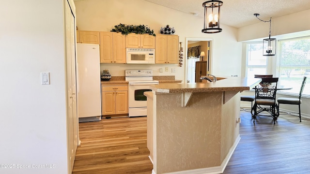 803 Crossbow Dr, West Melbourne, FL 32904 - kitchen featuring white appliances, light brown cabinets, light wood-type flooring, a textured ceiling, and a kitchen breakfast bar