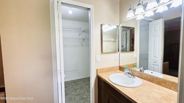 803 Crossbow Dr, West Melbourne, FL 32904 - bathroom with vanity, tile patterned floors, a textured ceiling, a spacious closet, and baseboards