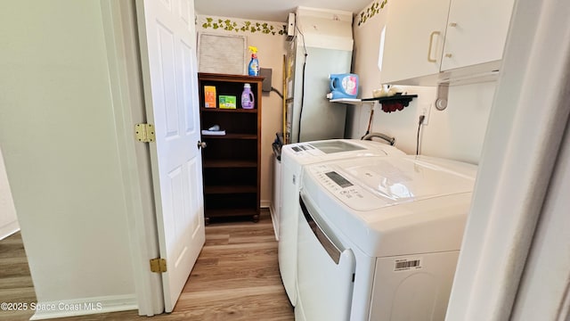 803 Crossbow Dr, West Melbourne, FL 32904 - laundry area featuring cabinet space, separate washer and dryer, and light wood-type flooring
