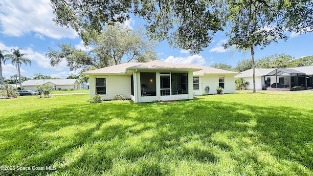 803 Crossbow Dr, West Melbourne, FL 32904 - rear view of house featuring a lawn, a sunroom, and stucco siding