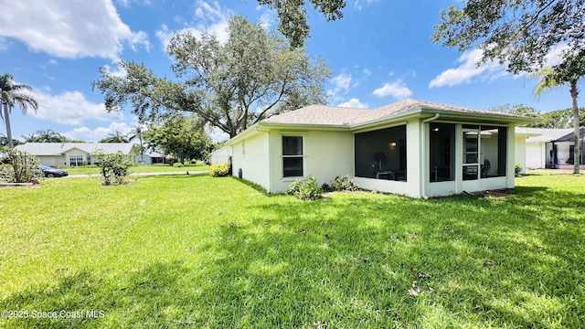 803 Crossbow Dr, West Melbourne, FL 32904 - rear view of property with a lawn, a sunroom, and stucco siding