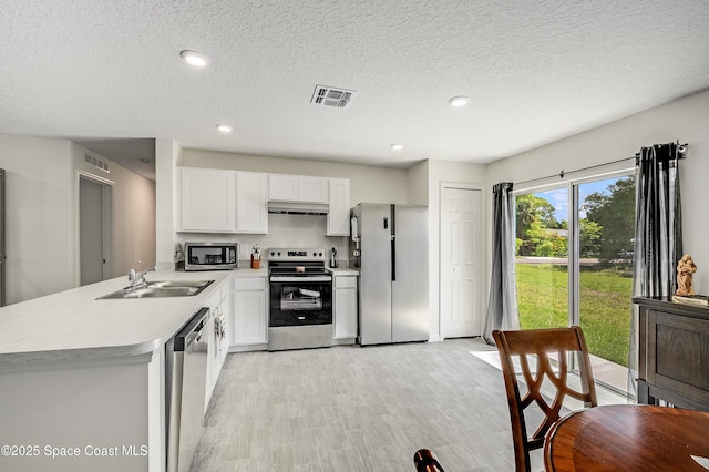 499 Grenadier Ave NW, Palm Bay, FL 32907 - kitchen with stainless steel appliances, a sink, light countertops, a peninsula, and under cabinet range hood