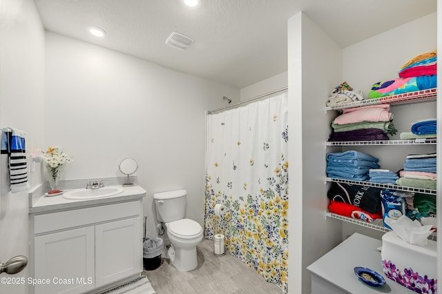 499 Grenadier Ave NW, Palm Bay, FL 32907 - bathroom featuring toilet, vanity, curtained shower, wood finished floors, and recessed lighting