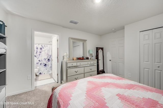 499 Grenadier Ave NW, Palm Bay, FL 32907 - carpeted bedroom featuring a closet, a textured ceiling, baseboards, and ensuite bath