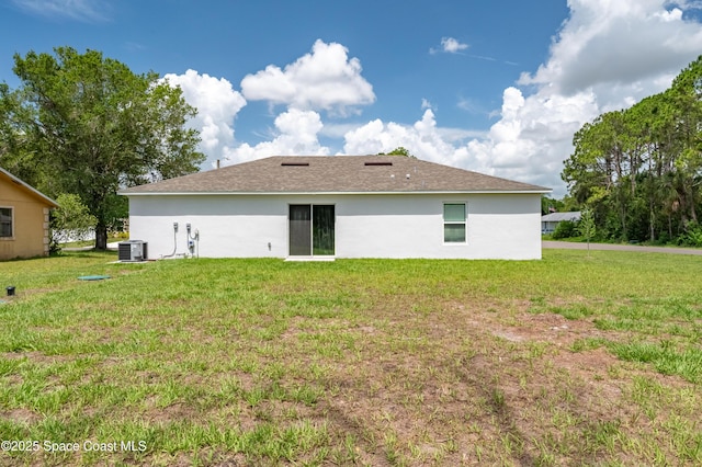 499 Grenadier Ave NW, Palm Bay, FL 32907 - back of house with central AC unit, a lawn, and stucco siding
