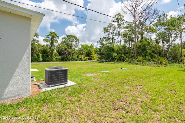 499 Grenadier Ave NW, Palm Bay, FL 32907 - view of grassy yard featuring central AC unit and view of wooded area
