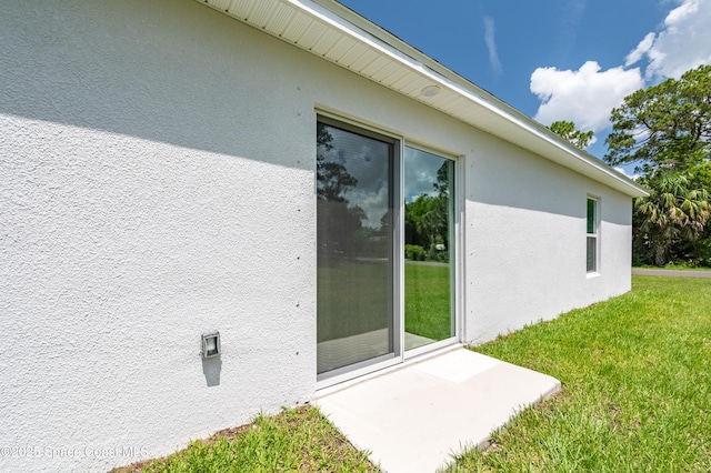 499 Grenadier Ave NW, Palm Bay, FL 32907 - doorway to property with stucco siding and a lawn