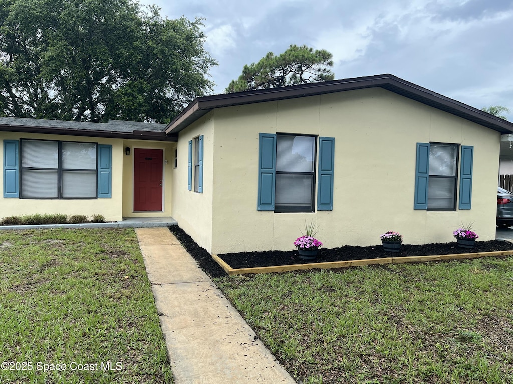 1148 Indrio Ln NE, Palm Bay, FL 32905 - view of front facade featuring stucco siding and a front yard