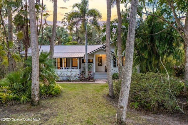 4185 Crooked Mile Rd, Merritt Island, FL 32952 - view of front of house featuring a yard, a porch, and metal roof