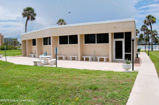 2020 N Atlantic Ave Unit 508-N, Cocoa Beach, FL 32931 - back of property featuring stucco siding, a yard, and a patio