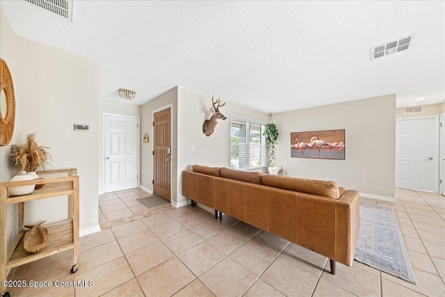 609 Tallwood Cir, Melbourne, FL 32904 - living area with light tile patterned flooring, a textured ceiling, and baseboards